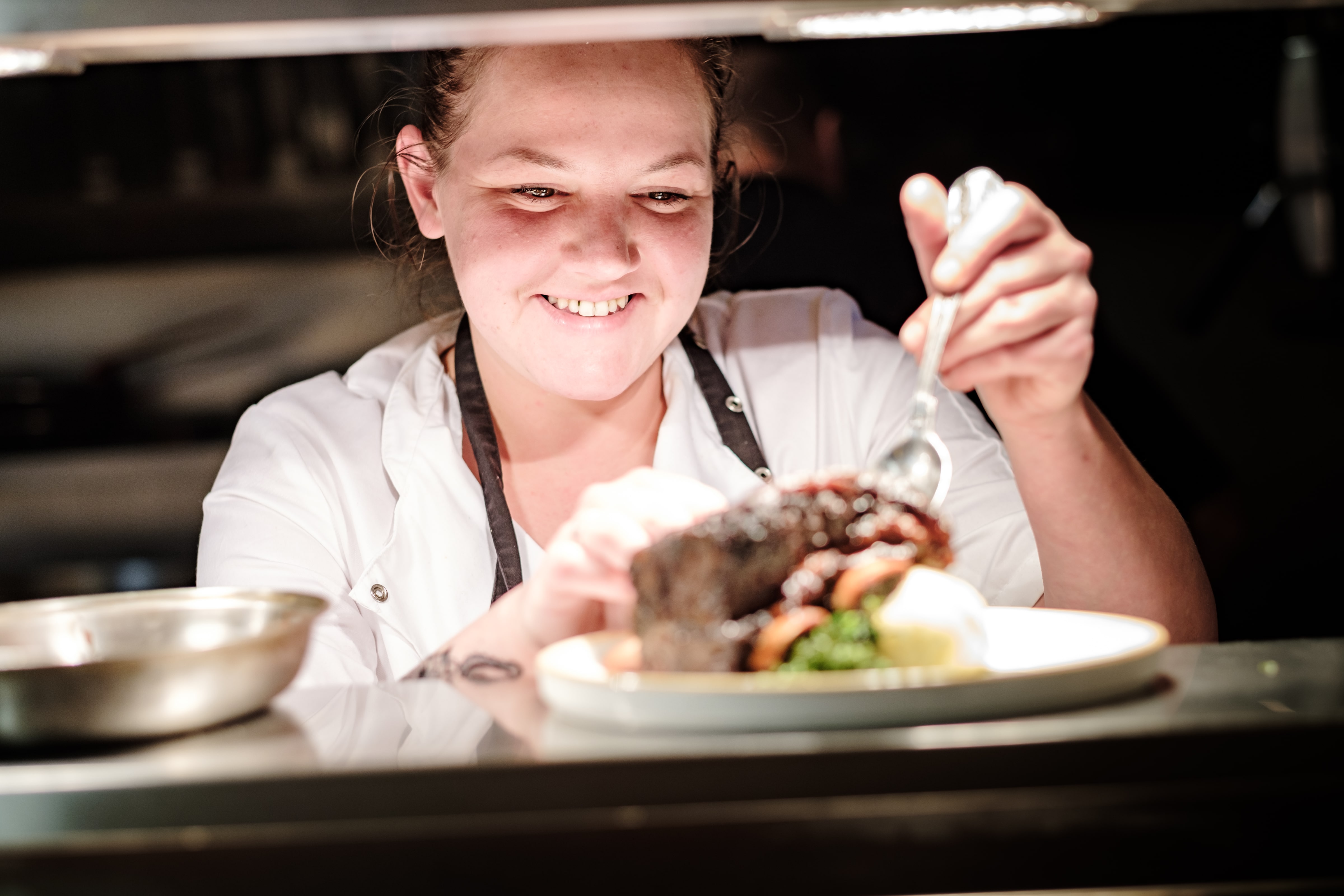 Aimee preparing food under a hot plate