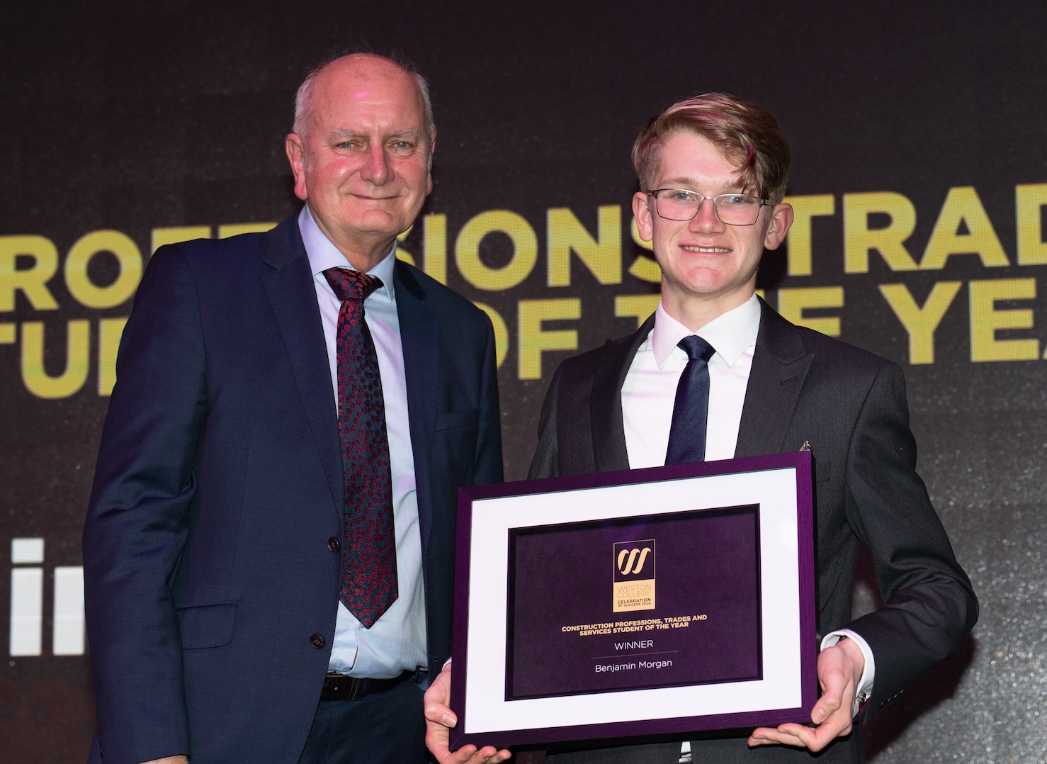 benjamin morgan standing on stage reciving an award