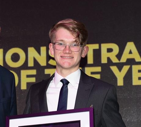 benjamin morgan standing on stage reciving an award