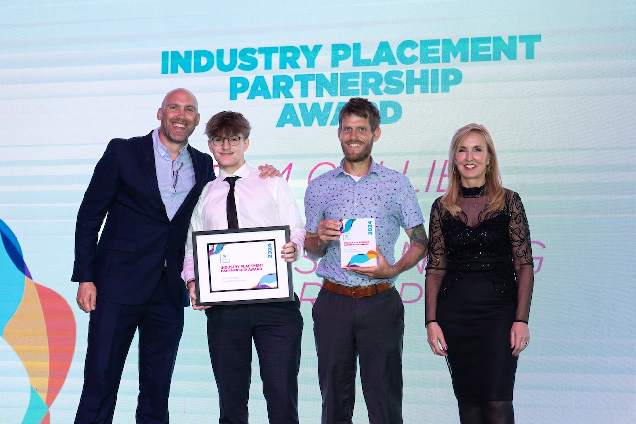 Tom, standing on stage with his employer, Jaqui Ford and Joe Simms accepting his award