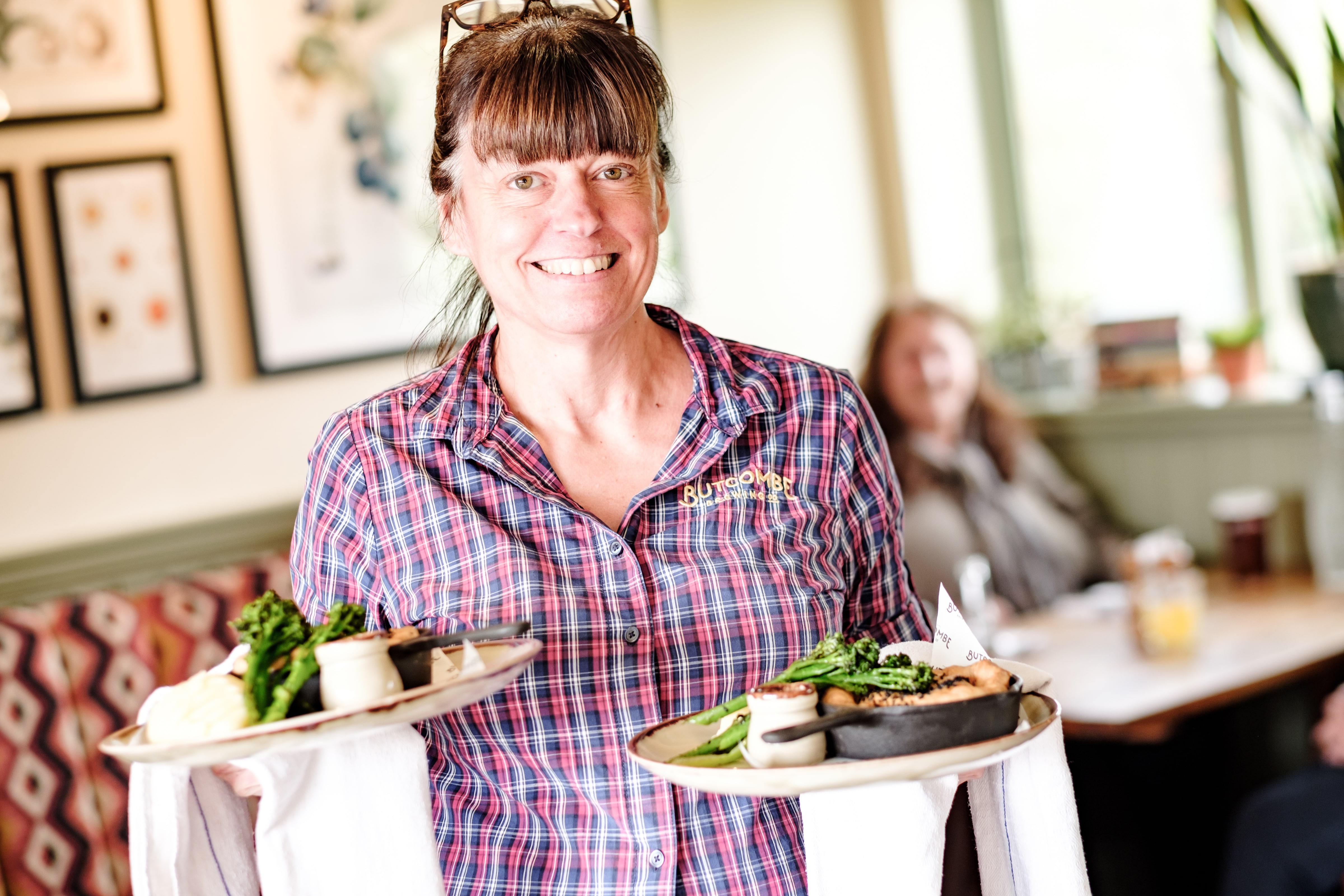  a happy women waitress holding two plates