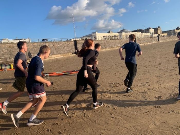 Students keeping fit running on the beach