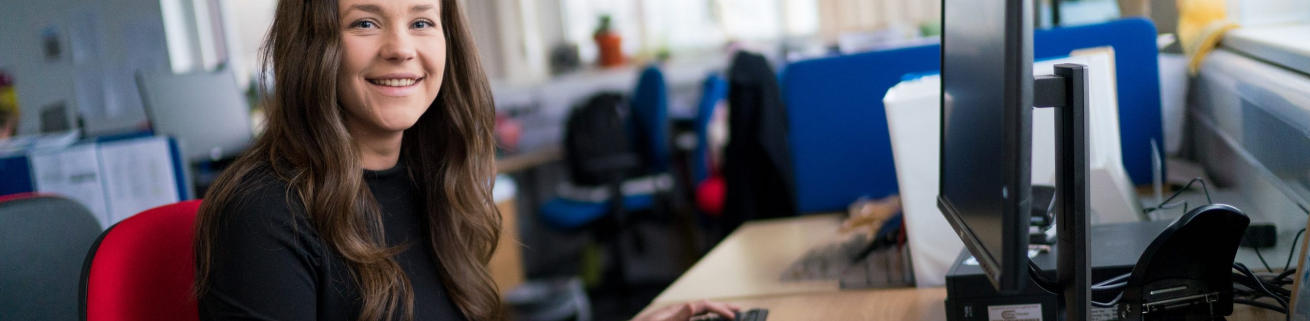 female student sat at computer at university centre weston offering higher education degrees in north somerset near bristol