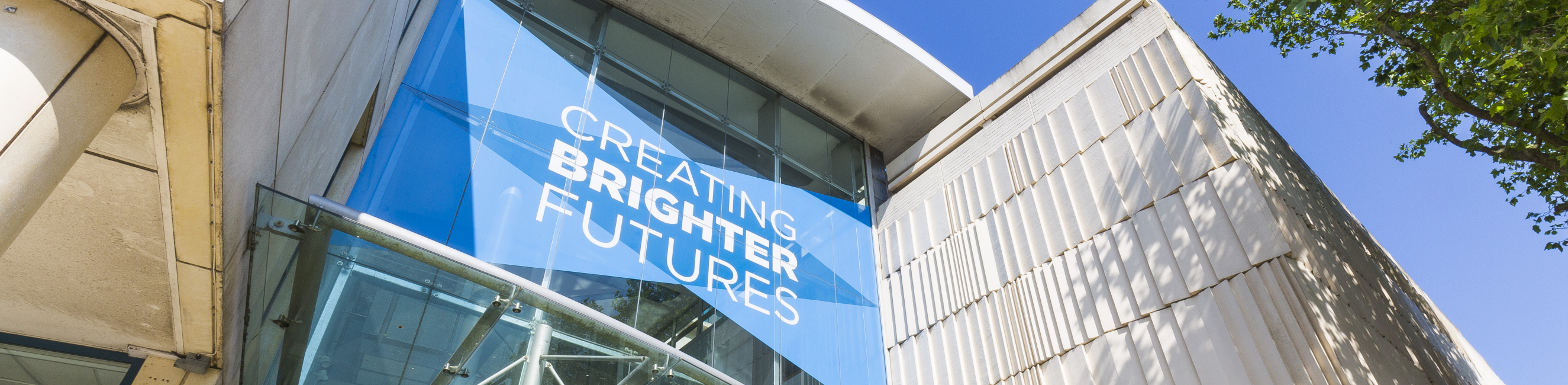 Outside Weston College Knightstone Campus with sign that says "Creating Brighter Futures"