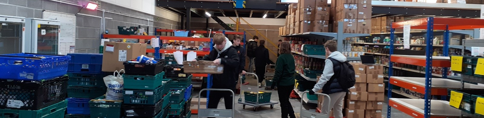 Learners stocking food onto trolleys in a warehouse