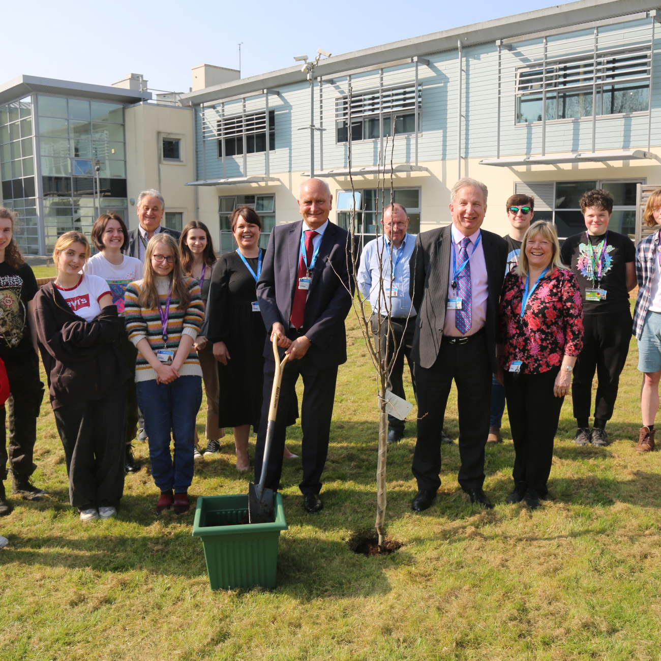 Creative arts students standing next to college principle, governors and staff planting an apple tree at Loxton campus