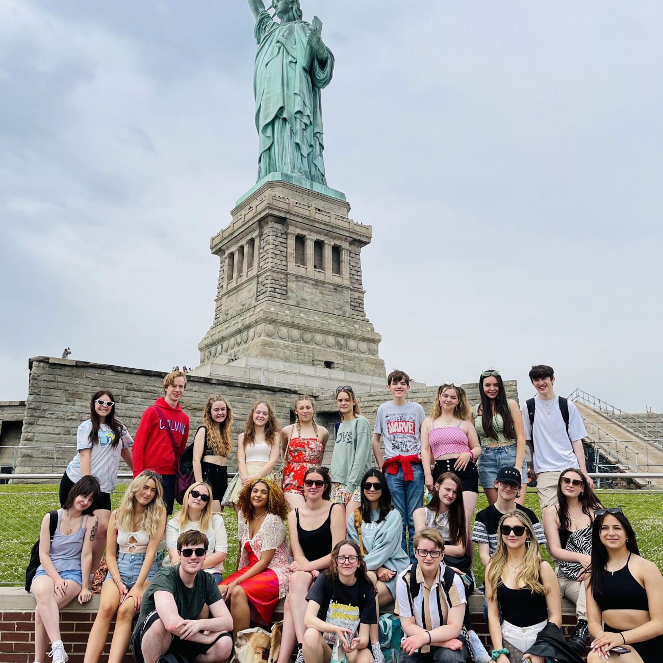 performing arts students stood next to the statue of liberty in new york