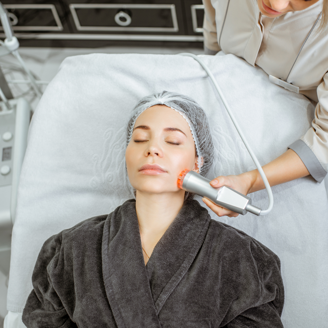 Woman on treatment bed receiving facial treatment