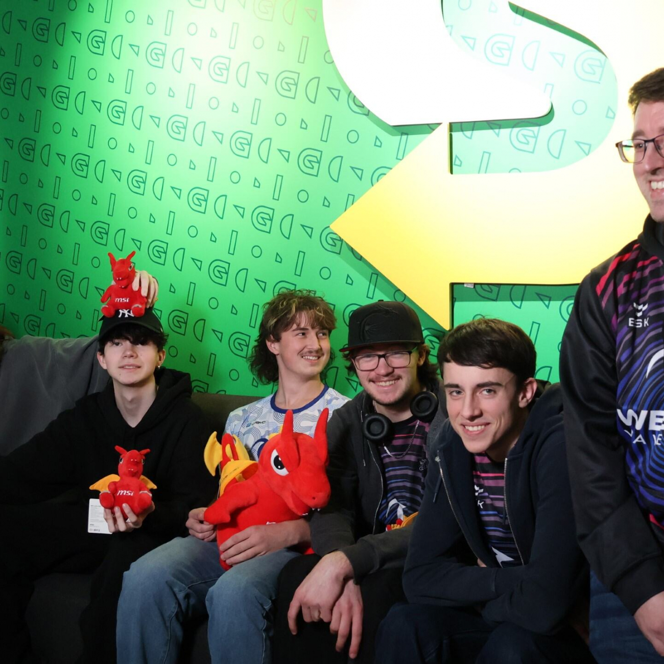 Esports students and lecturer group photo with their new dragon plushies from the tournament