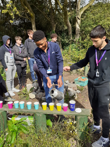 Learners pouring the water they boiled to make drinks for the class