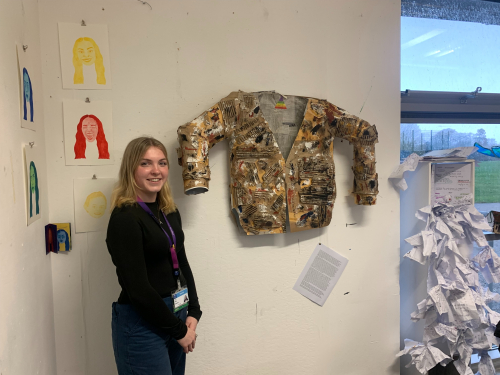 Amy standing next to her her project: a paper mache suit jacket