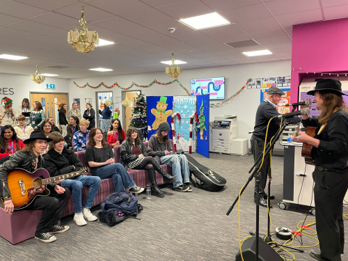 Music learner singing and playing the guitar to an audience