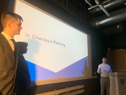 3 students standing next to their In Charley's Memory presentation