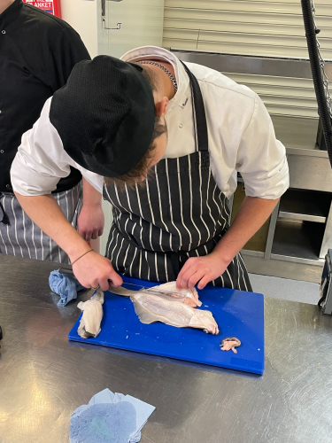 A student preparing a fish