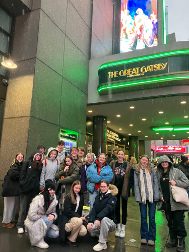 Students posing in front of 'The Great Gatsby' sign