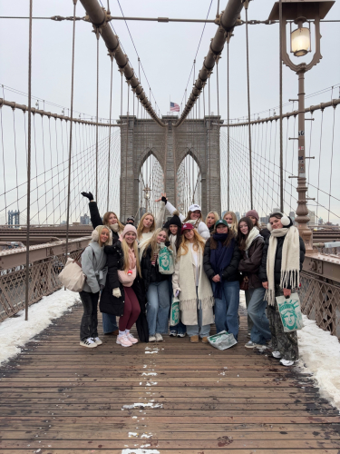 Students standing on Brooklyn Bridge smiling