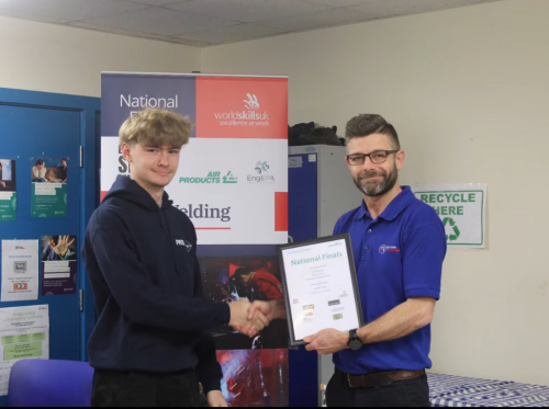 Aidan holding his Highly Commended award shaking someone's hand