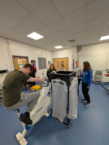 Student on a bike while other students measure his oxygen