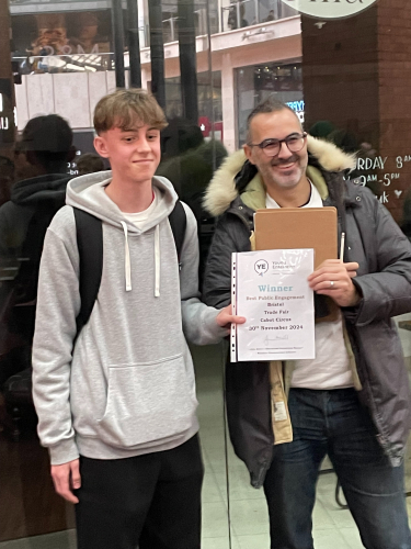 A learner holding up his certificate