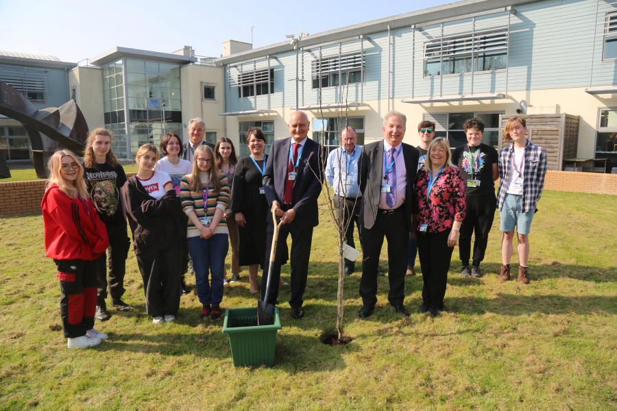 Creative arts students standing next to college principle, governors and staff planting an apple tree at Loxton campus