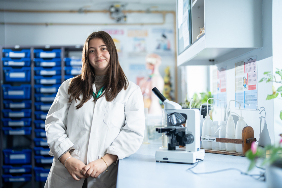 female student in lab coat in a laboratory 