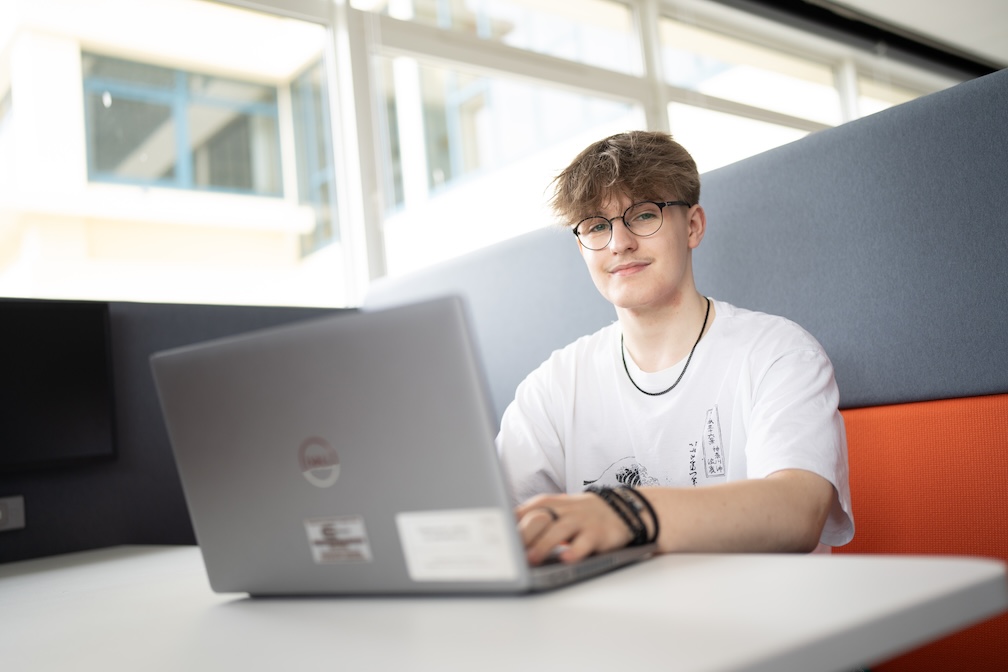 Tom Collier sitting at a desk on a computer